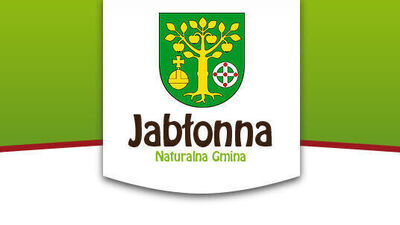 Herb Jabłonny przedstawia złote drzewo z owocami na zielonym tle, pod nim jabłko oraz tarczę. Poniżej napis "Jabłonna Naturalna Gmina" w brązowo-zielonej kolorystyce.