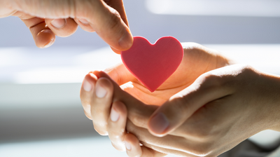 zdjęcie dłoni przekazującej serce na wyciągnięte dwie dłonie