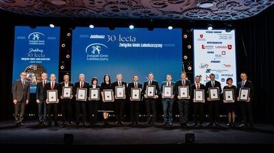 grupa osób trzymająca dyplomy jubileuszowe