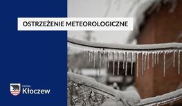 Na obrazie widnieje fragment gałęzi pokrytego lodem i soplami, co wskazuje na zimowe warunki atmosferyczne. Po lewej stronie na niebieskim tle znajduje się napis: "OSTRZEŻENIE METEOROLOGICZNE", a poniżej logo Gminy Kłoczew, które składa się z symbolu niedźwiedzia i biało-czerwonych pasów. Obraz informuje o trudnych warunkach pogodowych i potencjalnym zagrożeniu związanym z zimową aurą.