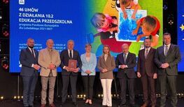 Przedstawiciele Gminy Kłoczew,  Urzędu Marszałkowskiego i województwa lubelskiego . W tle widoczny jest ekran z informacją o podpisaniu 46 umów w ramach programu Fundusze Europejskie dla Lubelskiego 2021–2027 dotyczącego edukacji przedszkolnej oraz grafika przedstawiająca bawiące się dzieci.”