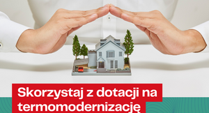 Osoba w białej koszuli trzyma uniesione dłonie nad modelem domu i drzewkami. Na dole napis: "Skorzystaj z dotacji na termomodernizację." Logo WFOŚiGW w lewym górnym rogu.