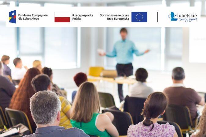 Grupa ludzi siedzi na sali wykładowej, słuchając prezentacji. Prelegent stoi przed audytorium. Na górze obrazu widoczne są logotypy funduszy europejskich i województwa lubelskiego.