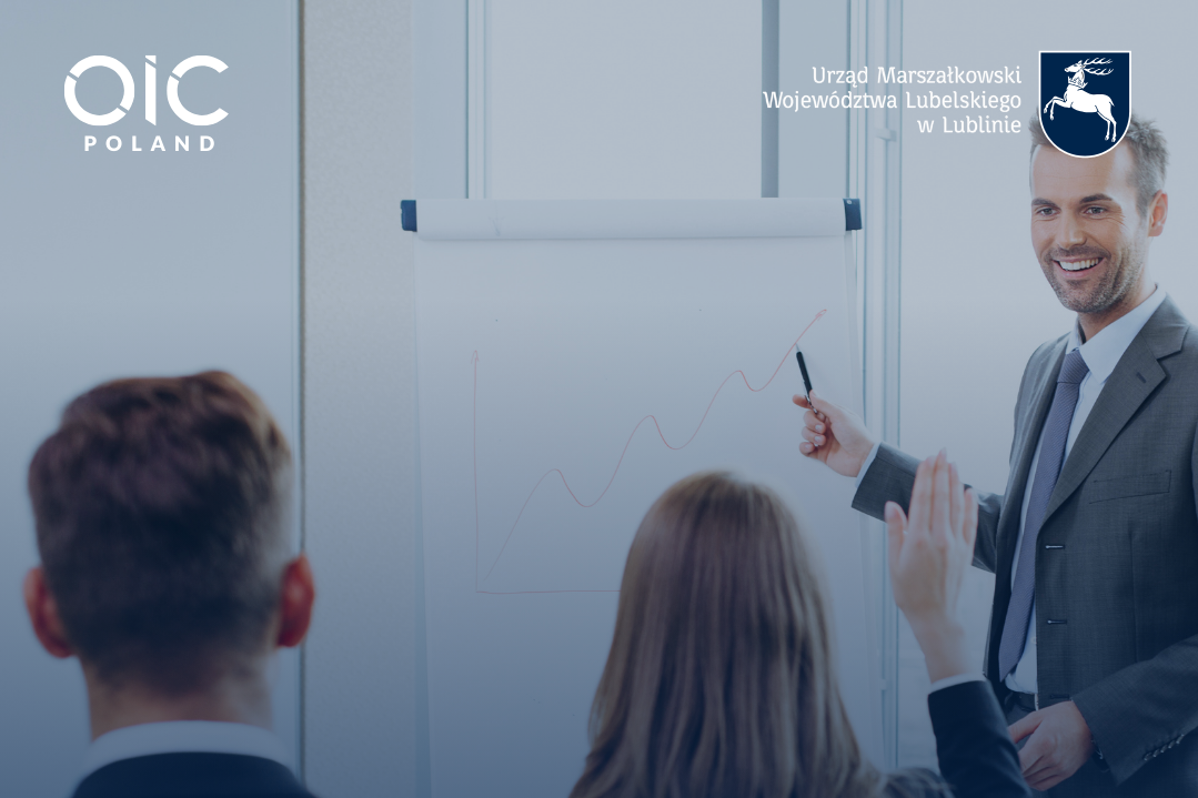 Na zdjęciu widać mężczyznę w garniturze prowadzącego prezentację, wskazuje na wykres na tablicy. W tle uczestnicy siedzą przy stole. Baner informuje o warsztatach dla lubelskich MŚP dotyczących rynków zagranicznych.