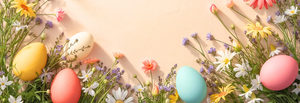 Kolorowe pisanki w pastelowych odcieniach umieszczone na łagodnym, pastelowym tle. Pomiędzy jajkami widoczne są różnorodne wiosenne kwiaty, tworzące wesoły i świąteczny nastrój.