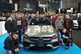 Zdjęcie przedstawia uczniów pozujących przy aucie marki Mercedes 