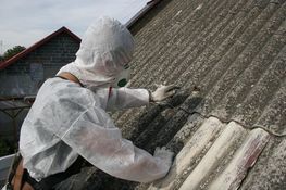 Osoba usuwająca azbest w specjalnym kombinezonie
