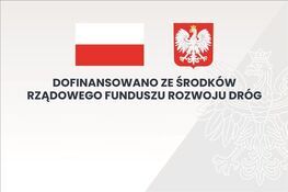 Flaga Polski i godło z białym orłem na czerwonym tle. Napis: "Dofinansowano ze środków Rządowego Funduszu Rozwoju Dróg" na szarym tle z konturem orła.