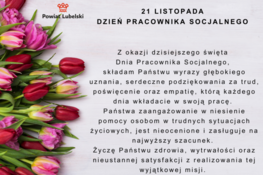 Zdjęcie przedstawia grafikę z tekstami, życzeniami z okazji Dnia Pracownika Socjalnego, otoczoną bukietem różowych tulipanów i czerwonych goździków na białym tle.