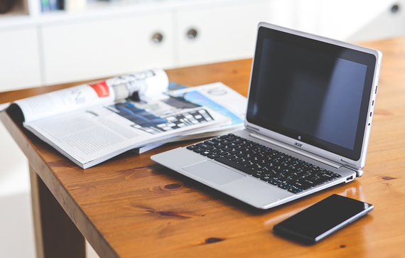 Grafika przedstawiająca biurko, laptopa oraz dokumenty i telefon