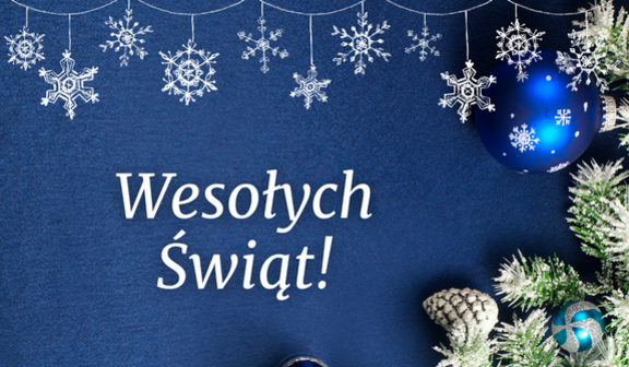 Na granatowym tle wisi łańcuch z białymi płatkami śniegu. Po prawej stronie znajdują się świąteczne bombki w niebieskiej kolorystyce, oplecione sztucznymi gałązkami. W centrum napis "Wesołych Świąt!".