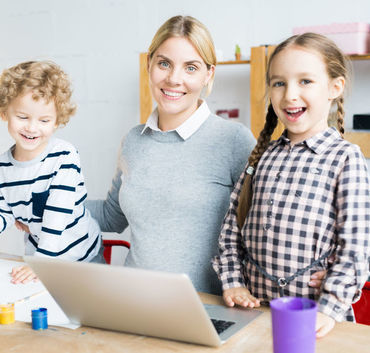 Kobieta z dwójką dzieci przy laptopie