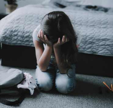 Płaczące dziecko siedzące na dywanie