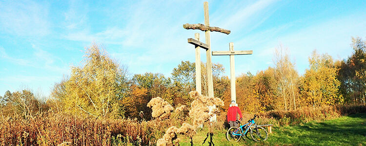 Góra Trzech Krzyży w Parchatce, drzewa w jesiennych barwach, rowerzysta