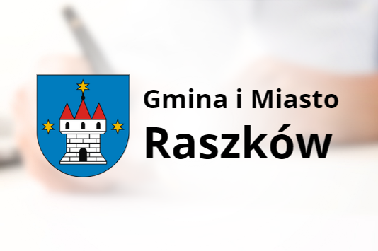 Herb Gminy i miasta Raszków na tle osoby podpisującej dokumenty