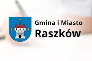 Herb Gminy i miasta Raszków na tle osoby podpisującej dokumenty