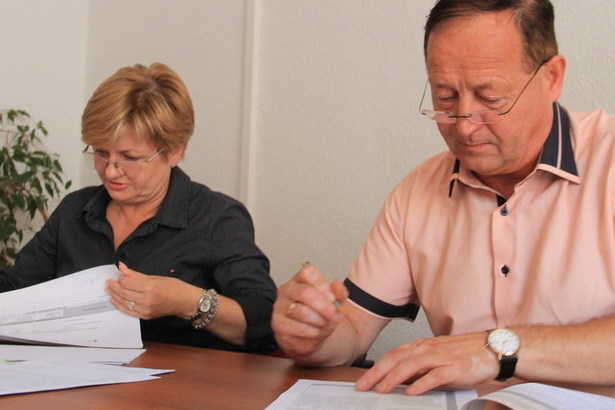Na zdjęciu kobieta i mężczyzna podpisujac umowy