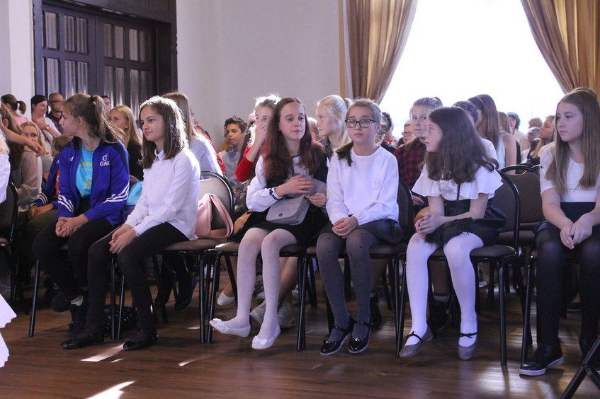 Zdjęcie uczniów siedzących na krzesłach podczas uroczystości