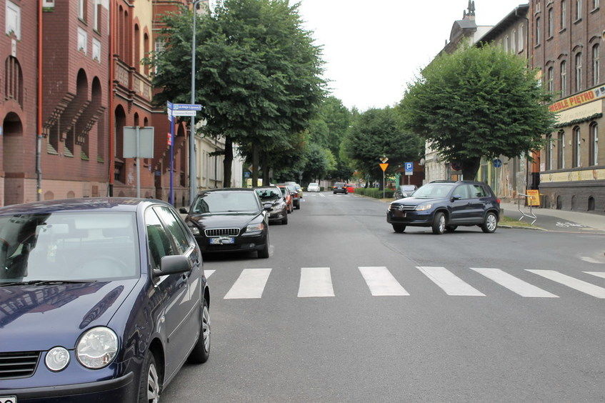 Na zdjęciu widok ulicy i zaparkowanych samochodów