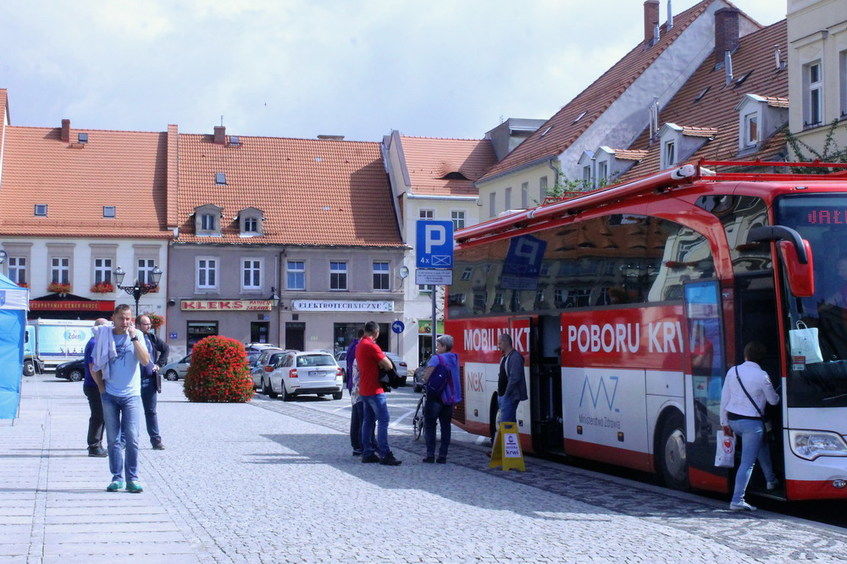 Na zdjęciu widać autobus Mobilny Punk poboru krwi i ludzi spacerujących