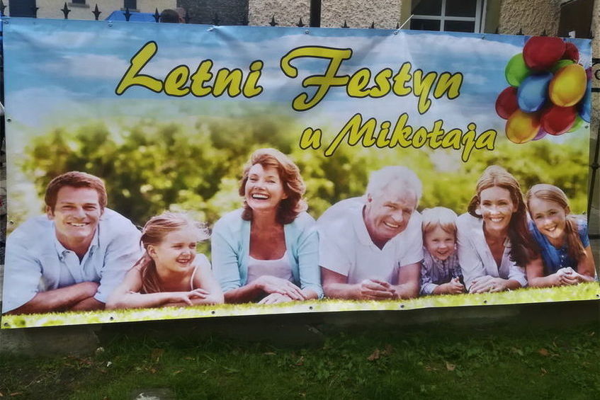 Baner Letni festyn u Mikołaja, na banerze zdjęcie szczęśliwej wielopokoleniowej rodziny.