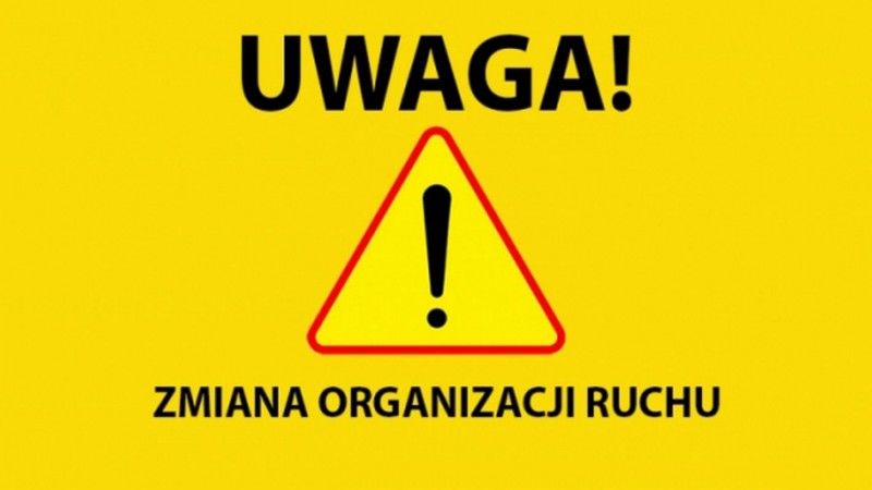 Napis UWAGA (znak drogowy z wykrzyknikiem) ZMIANA ORGANIZACJI RUCHU na zółtym tle