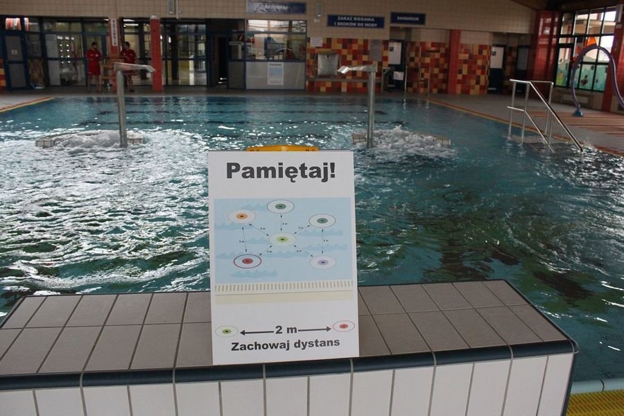 Zdjęcie tabliczki z informacjami, o czym pamiętać na basenie, w tle basen