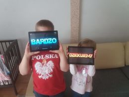 Zdjęcie dzieci trzymające przy twarzach tablety. na tabletach napisy Bardzo Dziękujemy