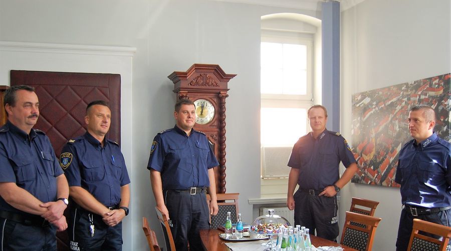 Zdjęcie przedstawia strażników straży miejskiej i burmistrza podczas spotkania w gabinecie. 