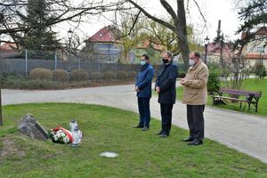 Trzy osoby stojące przed tablicą pamiątkową w Parku Miejskim