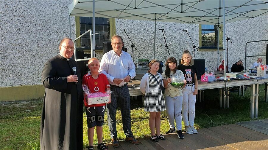 Na zdjęciu widoczny jest Proboszcz parafii św. Mikołaja, Burmistrz Miasta oraz uczestniczka loterii fantowej. 