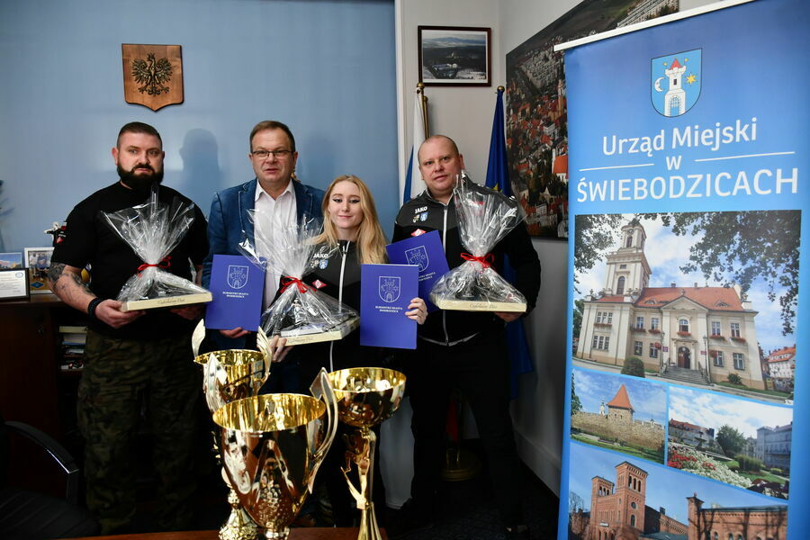 Na zdjęciu widoczne są cztery osoby. Trzech mężczyzn i kobieta.