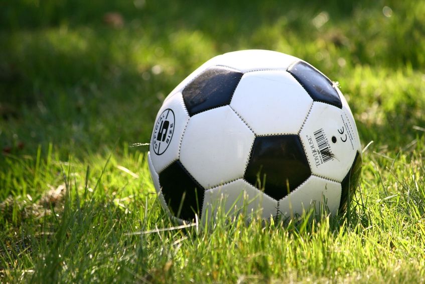 Na zdjęciu widoczna jest piłka futbolowa na trawie