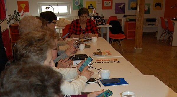 Wykadrowana zdjęcie przedstawiające seniorów ze smartfonami
