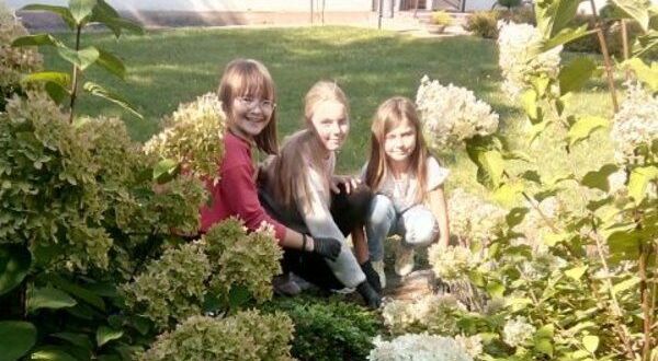 Razem chronimy środowisko- trzy dziewczynki pomiędzy roślinami