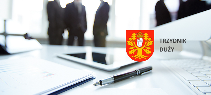 Zdjęcie biura z zamazanymi sylwetkami osób w tle, laptopem, dokumentami i długopisem na biurku na pierwszym planie, oraz herbem miasta Trzydnik Duży w prawym górnym rogu.