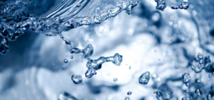 Niejednolite krople wody rozpryskują się na błękitnym tle, z naciskiem na przejrzystość i dynamikę ruchu.