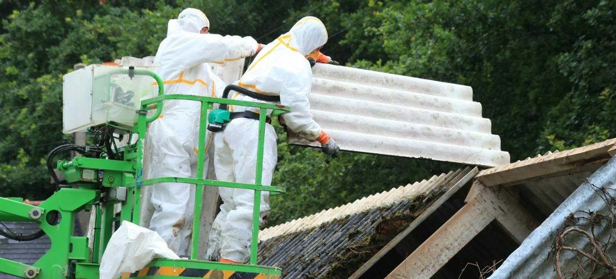 Dwie osoby zabierają dach z azbestu