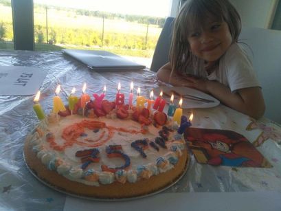 Tort ze świeczkami i uśmiechnięta dziewczynka