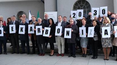 Przedstawiciele samorządów trzymający litery składające się na hasło: Dekarbonizacja 2030