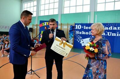 burmistrz Leszek Michalak oraz zastępca burmistrza Przemysław Sikora podczas przekazania bonu podarunkowego dyrektor szkoły Krystynie Waliszak