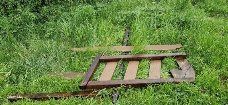 Zdjęcie przedstawiające drewnianą paletę leżącą na zielonej trawie