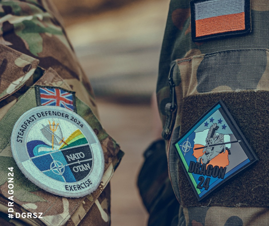 Zdjęcie munduru wojskowego z naszywkami: jedna z flagą Polski, druga z logo NATO i napisem „Steadfast Defender 2021”, oraz trzecia z symbolem „Dragon 24”.