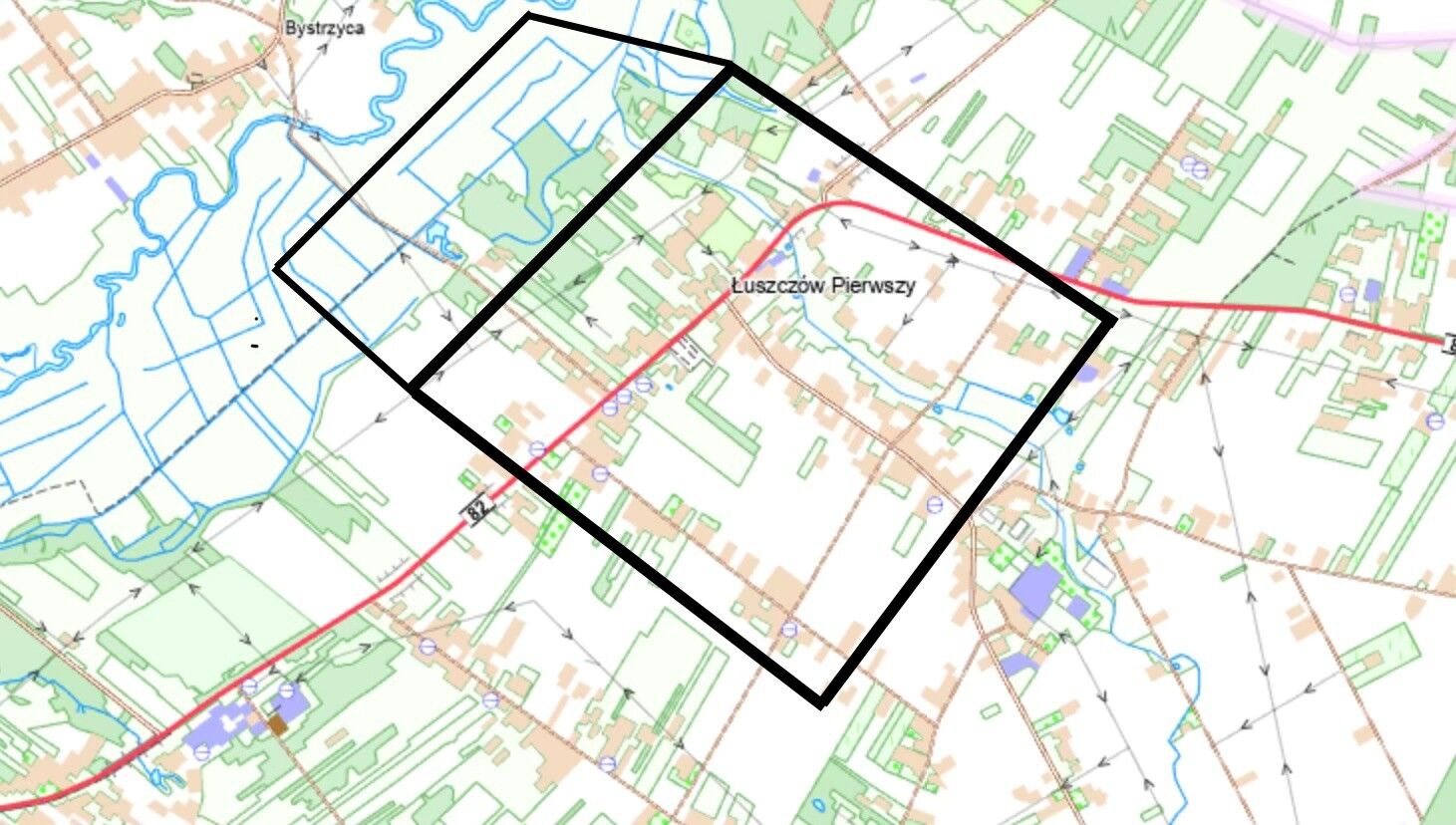 Mapa przedstawia obszar Luszczowa Pierwszego z zaznaczonymi drogami i rzeką. Widoczne są kształty działek oraz granice terenu oznaczone czarnym prostokątem. Okolica jest otoczona zielonymi terenami.
