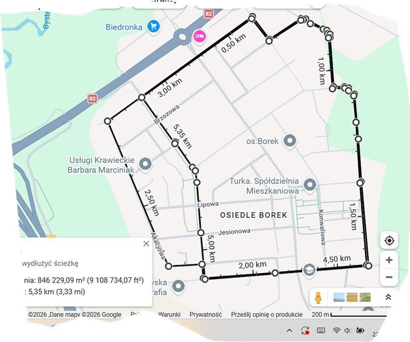 Mapa przedstawia trasę o długości 5,35 km na osiedlu Borek, zaznaczoną czarną linią. Trasa przebiega przez ulice, a na mapie widać punkty pomiaru odległości i nazwy lokalnych firm oraz sklep&oacute;w.