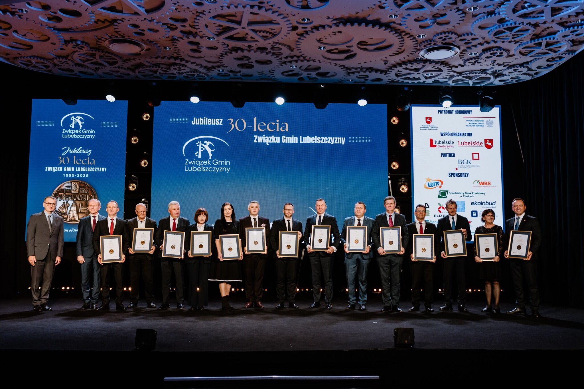 grupa osób trzymających dyplomy jubileuszowe