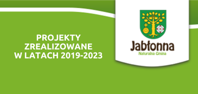 Obraz przedstawia białą flagę lub banner z herbem Gminy Jabłonna i napisem "PROJEKTY ZREALIZOWANE W LATACH 2019-2023" na tle zielonego pasa z lekkimi falami.