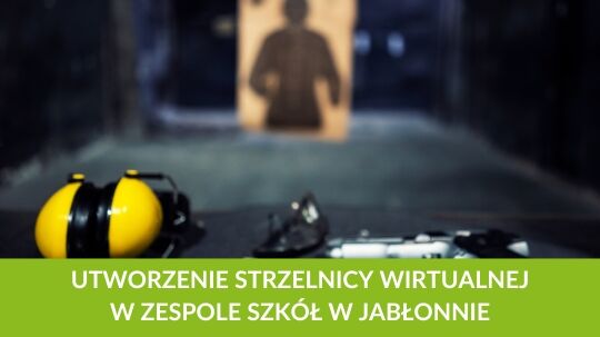 Zbliżenie na stolik ze słuchawkami ochronnymi i sprzętem strzeleckim. W tle rozmazany cel strzelniczy. Na dole napis: "Utworzenie strzelnicy wirtualnej w Zespole Szkół w Jabłonnie".