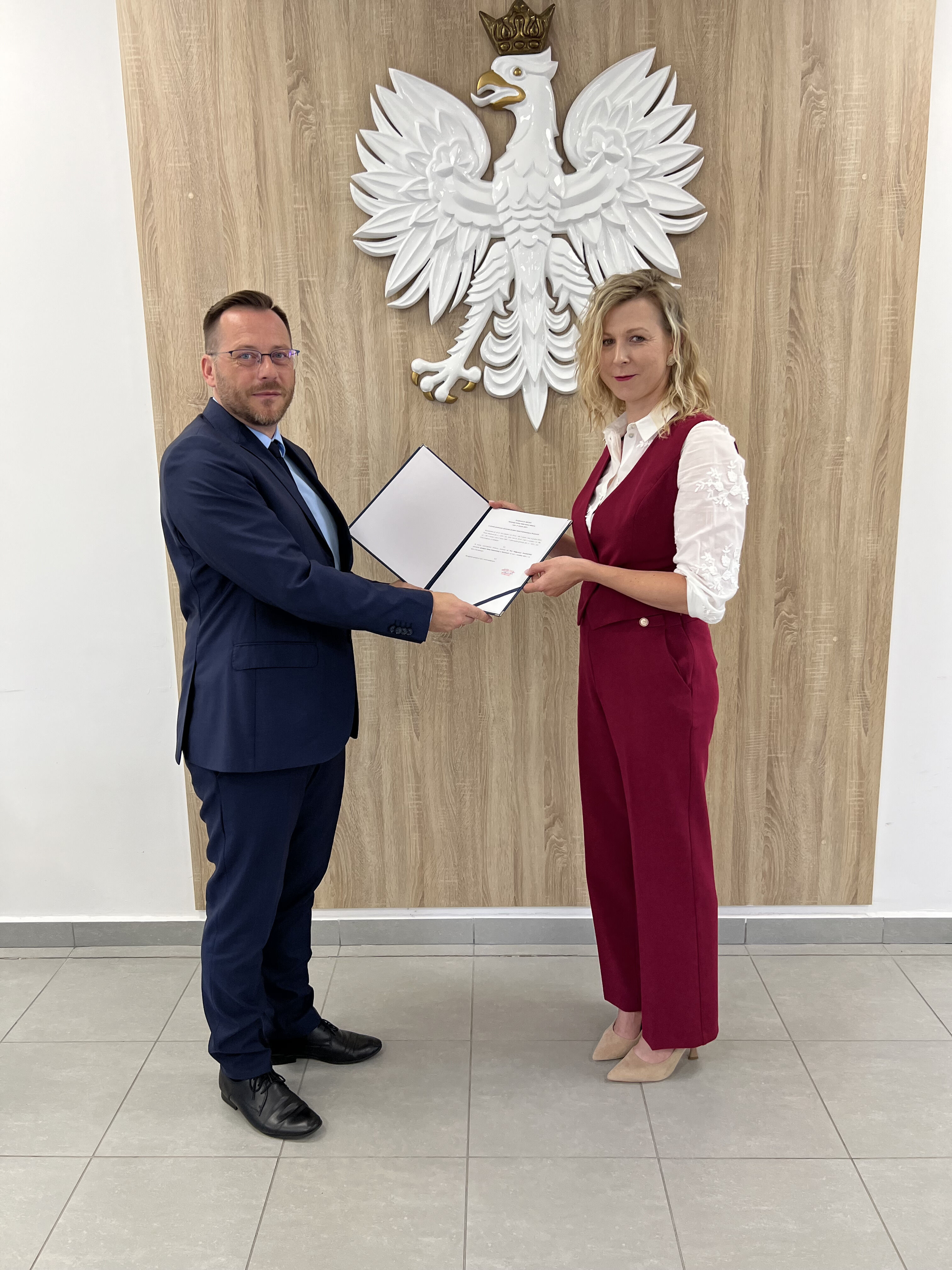 zdjęcie dwóch osób trzymających dokument