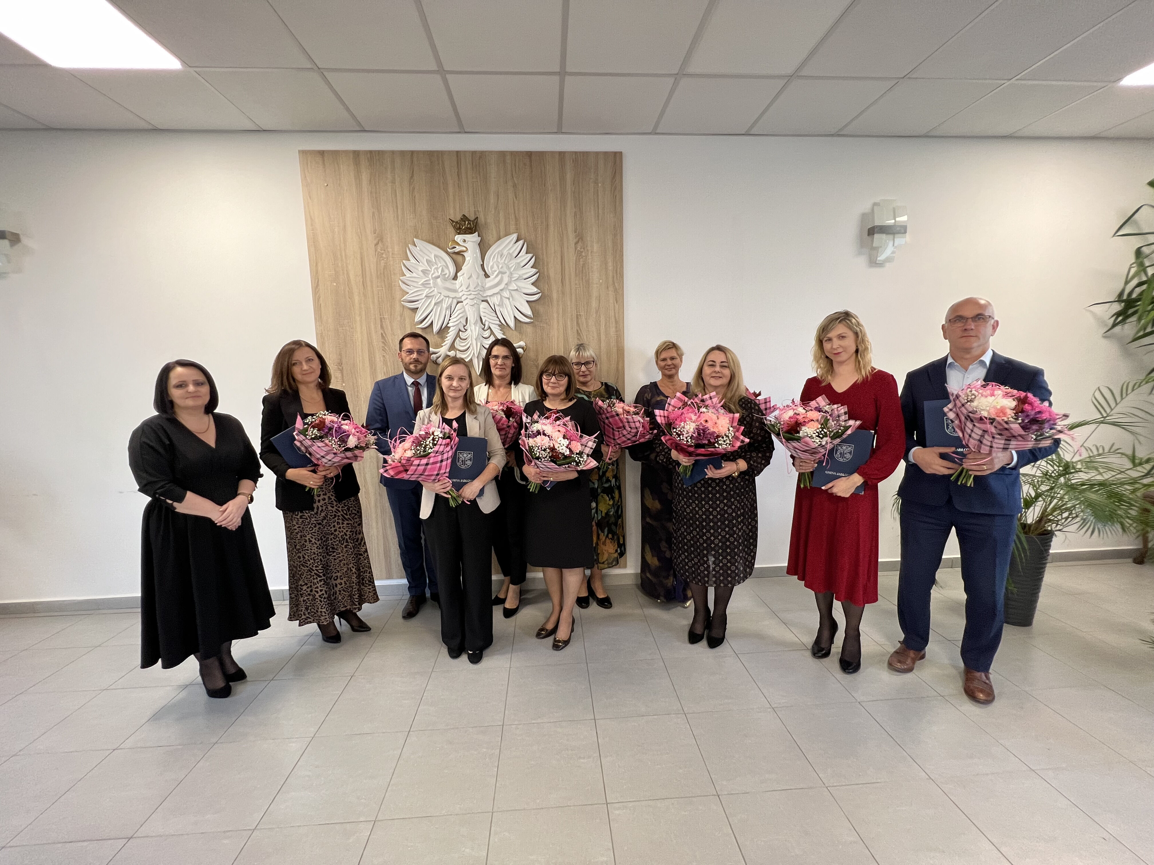 zdjęcie stojącej grupy ludzi, która trzyma bukiety